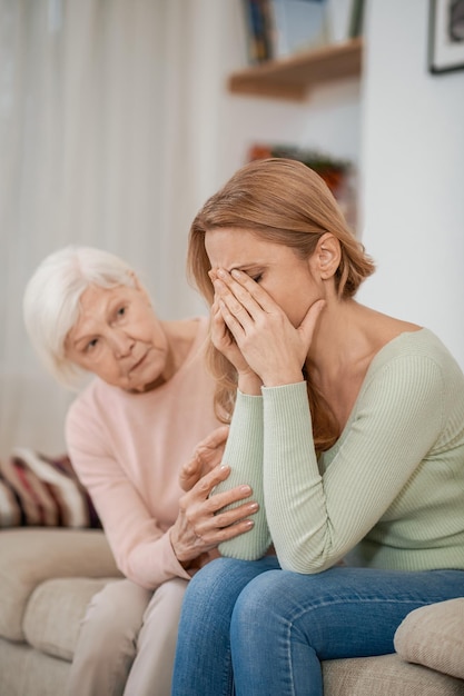 Liefhebbende bejaarde moeder die haar volwassen dochter troost