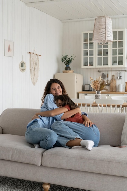 Liefhebbende moeder knuffelen omarmen met tienerdochter thuis gezonde ouder-kind relatie