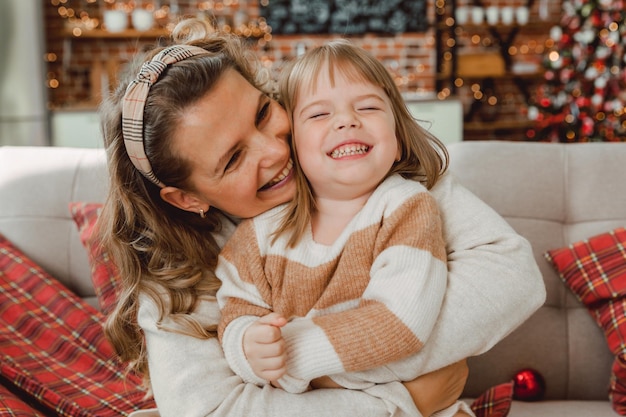 Liefhebbende moeder lachen, knuffelen lachende schattige kind dochter, gelukkig gezin, plezier hebben met spelen, vreugde voelen, knuffelen