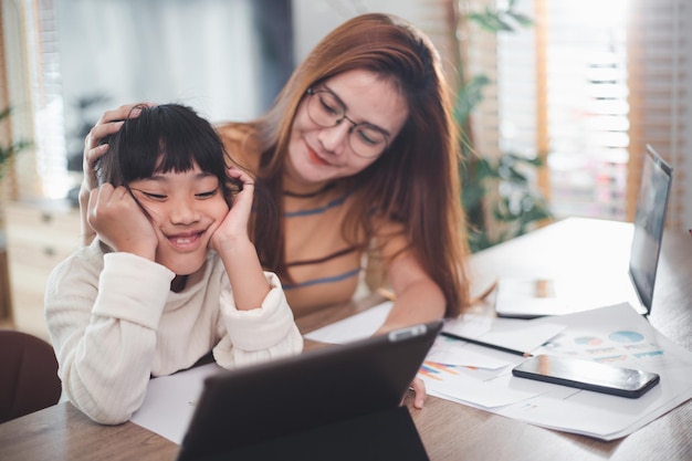 Liefhebbende moeder ondersteunt vermoeide dochterstudy samen thuis. moeder helpt schoolmeisje te troosten die moeite heeft met onderwijs thuis leren.