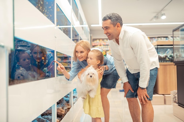 Liefhebbende ouders nemen hun kleine meisje in het weekend mee naar het aquarium