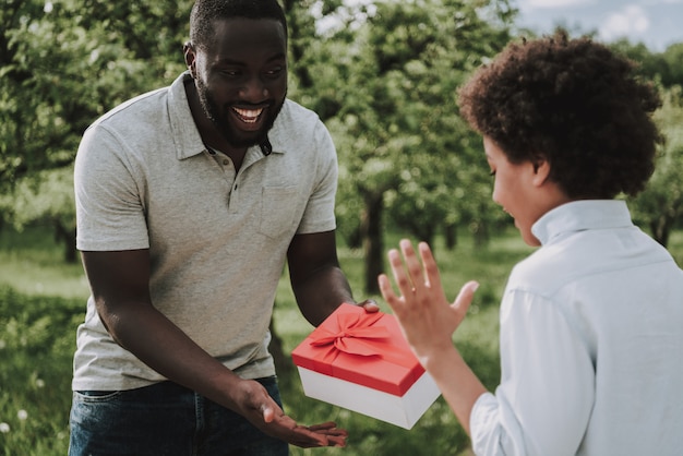 Liefhebbende vader geeft geschenk en kijkt naar zoon