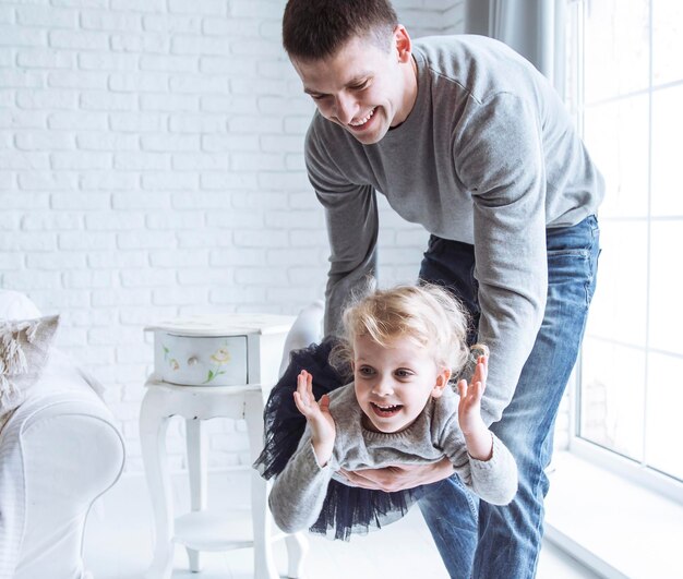 Foto liefhebbende vader speelt met zijn dochtertje