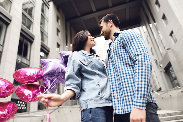 Liefhebbers kijken in ogen Jong koppel met ballonnen.