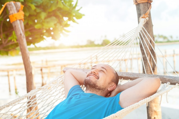 lies in a hammock and enjoys the rest