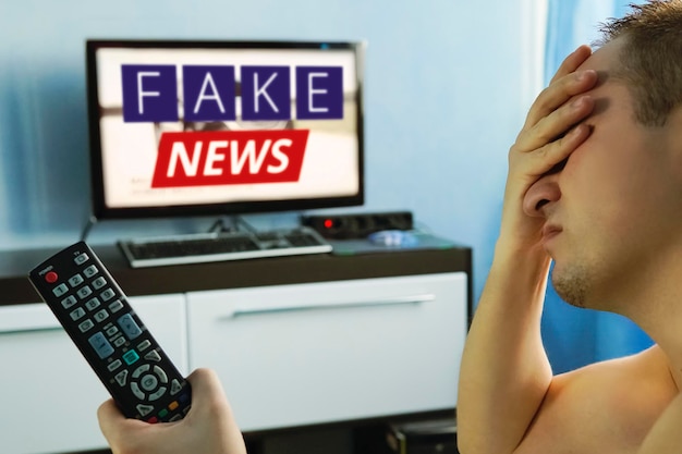 Photo lies of tv propaganda mainstream media disinformation a fake news report viewer is watching tv and doesn't believe in fake news man closes his eyes not to watch the lies on tv