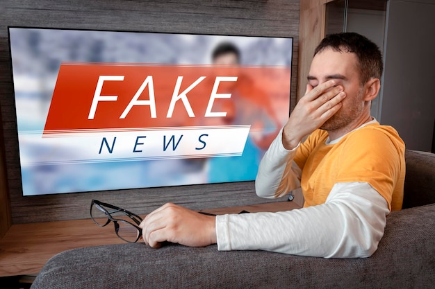 Lies of tv propaganda mainstream media disinformation a fake
news report viewer is watching tv and doesn't believe in fake news
man closes his eyes not to watch the lies on tv