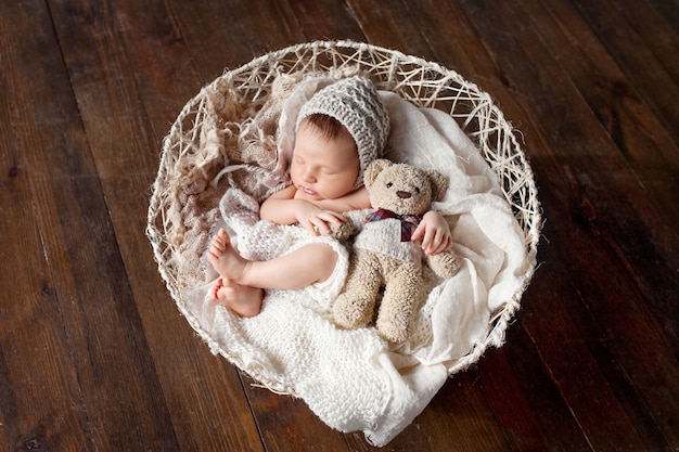 Lieve pasgeboren baby slaapt met een speeltje in de mand.