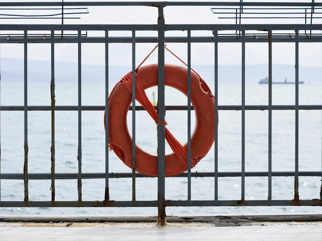 Photo life belt hanging on railing against sea