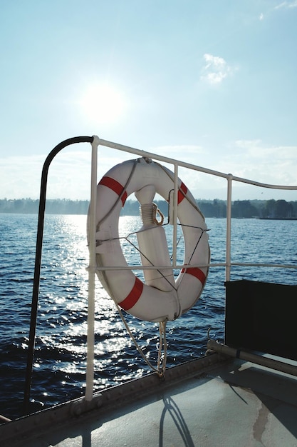 Life belt tied on boat in sea against sky