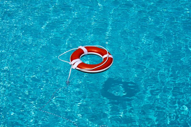 Life buoy in blue swimming pool lifebuoy pool ring float on blue water