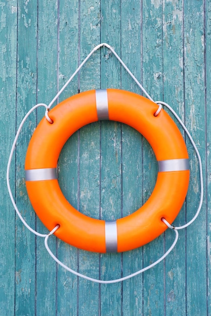 A life buoy on green wooden background