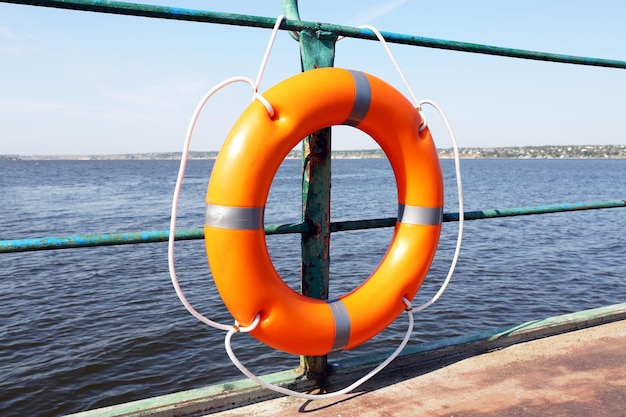 A life buoy hangs on the pier\'s handrail