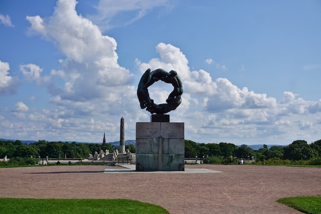 青空に浮かぶノルウェー、オスロ市、フログネル公園のヴィーゲラン公園にあるライフサークルの彫刻。人間のチームワーク、美しさ、強さ。