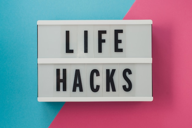 Life hacks - текст на дисплее на голубой и розовой яркой поверхности.