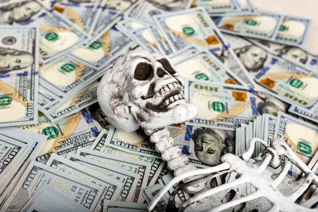 生命保険の死亡補償のコンセプト ドルの山の上の頭蓋骨のスケルトン
