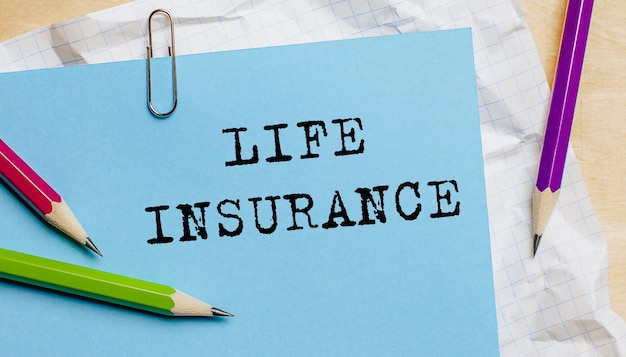 Photo life insurance text written on a paper with pencils in office