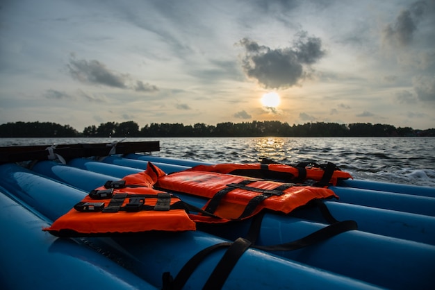 life jacket on pvc raft with sunset sky