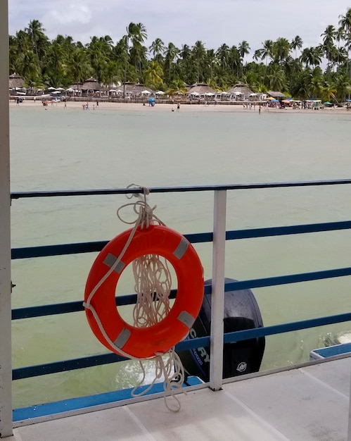 A life preserver hangs on a railing on a boat.