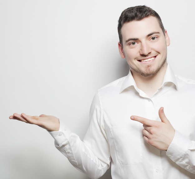 Life style, business and people concept: business man points with fingers in the right side over white background.