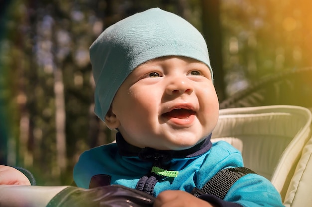 写真 ライフ スタイルのクローズ アップの肖像画の赤ちゃん男の子少しベビーカーに座っているし、晴れた日に笑顔