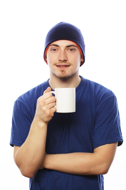 Life style, food  and people concept: casual young man holding white cup with coffee or tea.