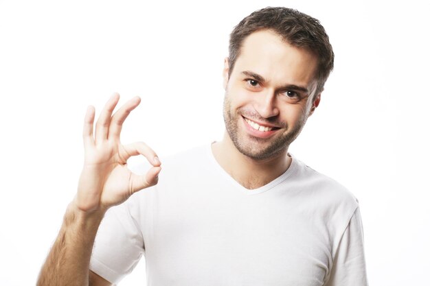 life style and people concept Happy handsome man wearing white tshirt showing thumbs up over isolated background