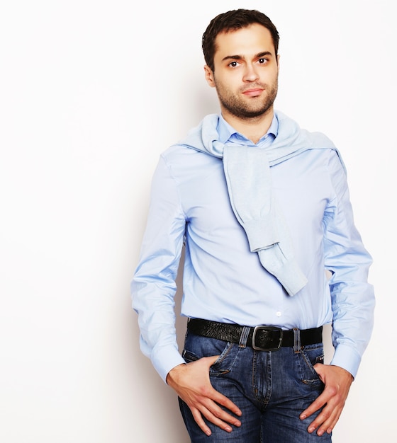 Life style  and people concept: happy young man in blue shirt. Over white background.