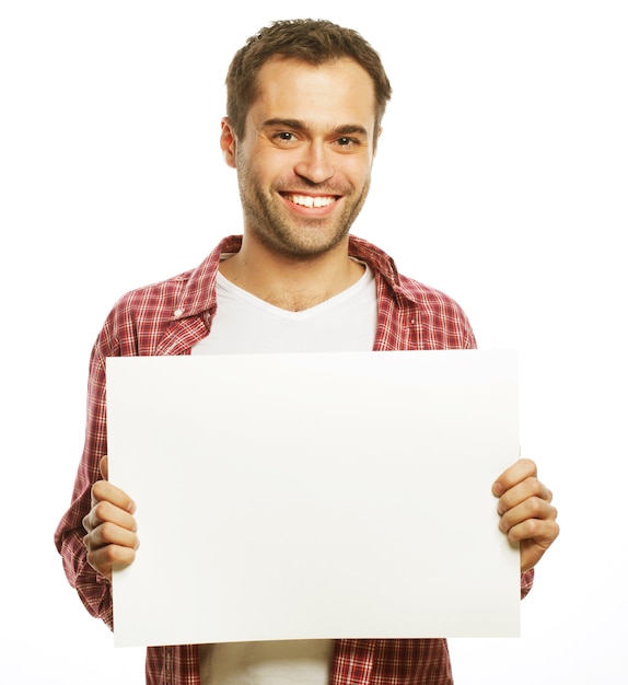 Stile di vita e concetto di persone: giovane uomo bello che mostra un cartello bianco, isolato su sfondo bianco