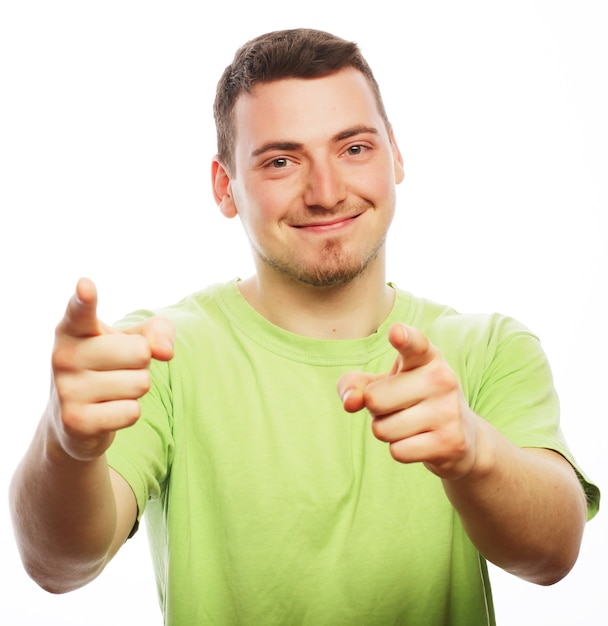 Life style  and people concept: Young smiling happy man shows something on white background.