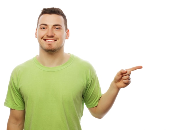 Life style  and people concept Young smiling happy man shows something on white background