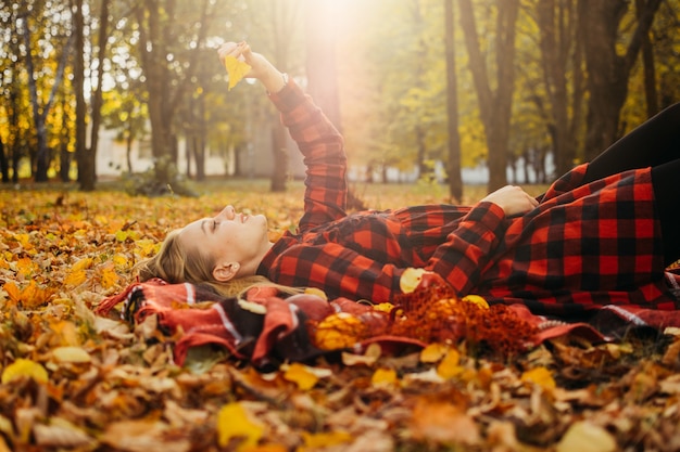 Life style portrait of happy woman in fall park beautiful girl on the nature picnic camping relaxing