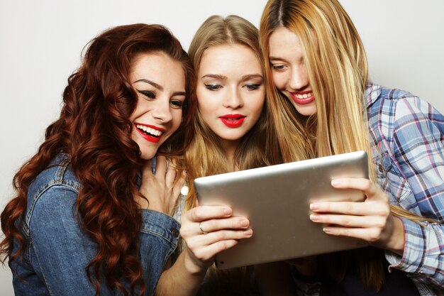 Life style, tehnology and people concept: hipster girls friends taking selfie with digital tablet