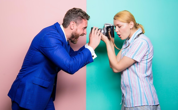 Life through the lens Fashion shooting in photo studio Pretty woman using professional camera Businessman posing in front of female photographer Photographer shooting male model in studio