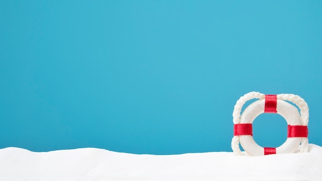 Lifebouy op wit zand copyspace voor tekst concept van de zomer