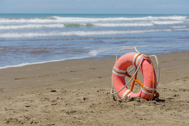 Lifebuoy on a deserted beach over blue sky