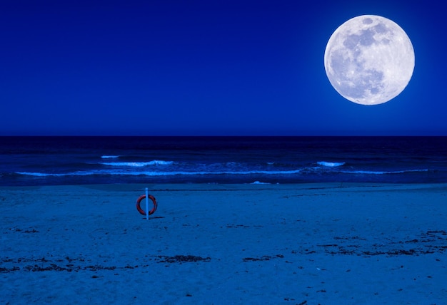 Lifebuoy on a deserted beach at night