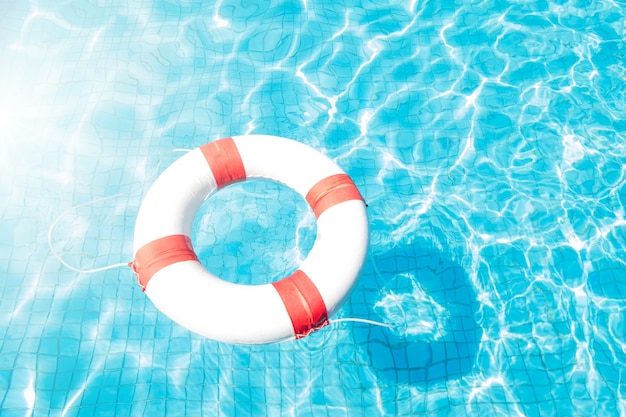 Спасательный круг, плавающий в голубом бассейне.