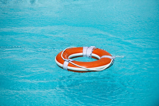 スイミングプールの救命浮環夏休みのコンセプト水中の救命浮き輪ヘルプコンセプト