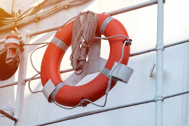 Фото Спасательный круг на поручнях фрегата или военного корабля. веревка намотана на поручни спасателем.