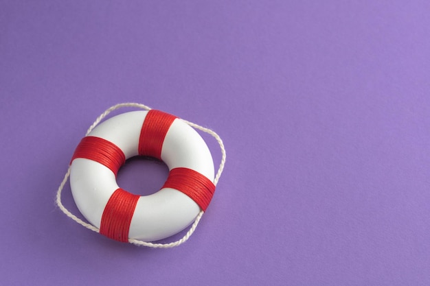 Photo lifebuoy on purple background copy space for text mockup