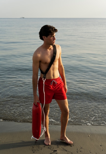 Lifeguard holding lifesaving buoy full shot