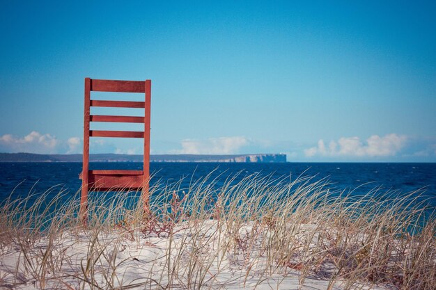 Lifeguard hut on beach against blue sky