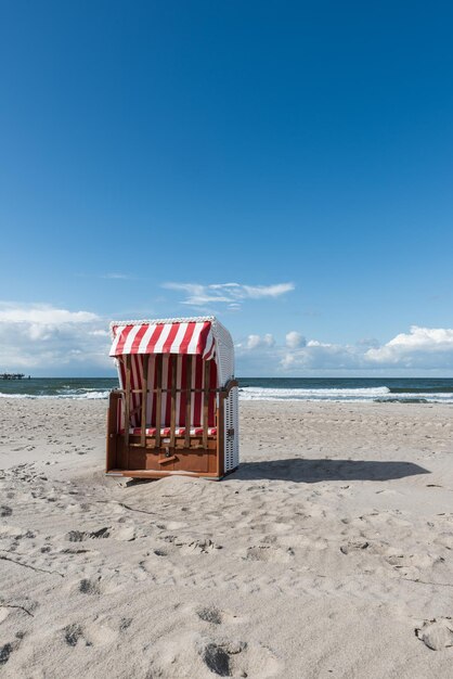 Lifeguard hut on beach against blue sky