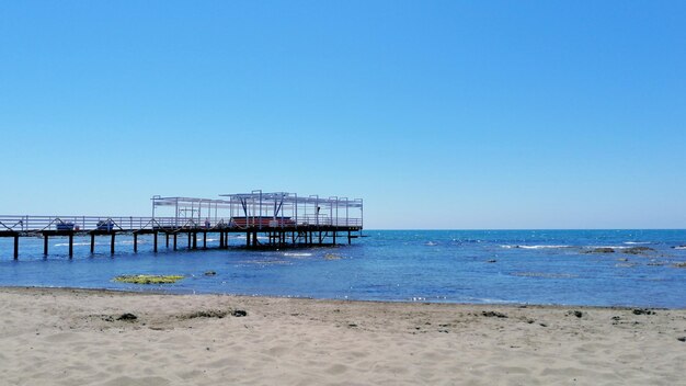 Lifeguard hut on beach against clear blue sky