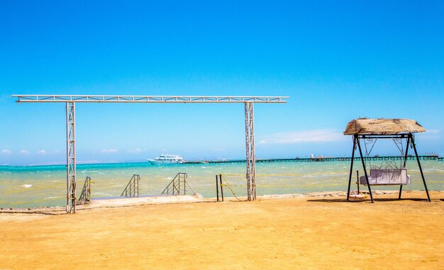 Lifeguard hut on beach against clear blue sky