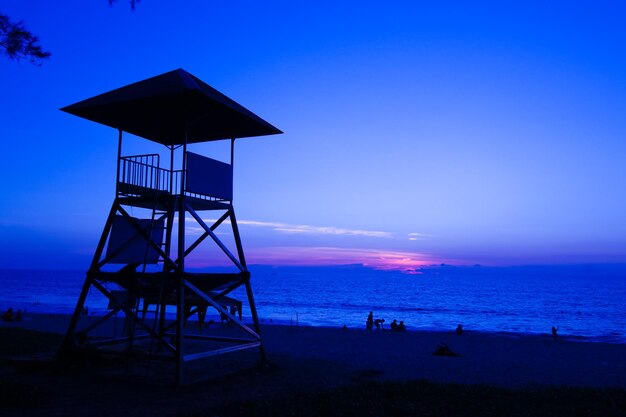 Lifeguard hut on beach against clear blue sky