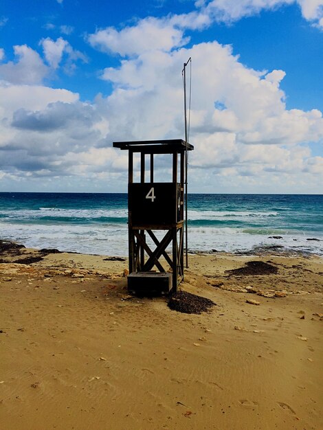 Foto cotta di salvataggio sulla spiaggia contro il cielo