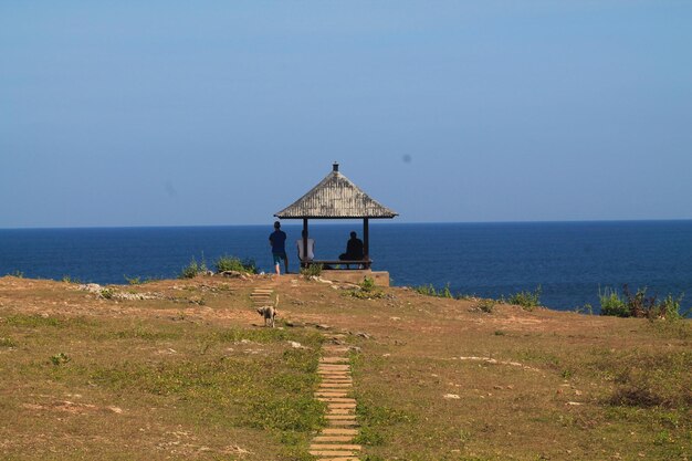 写真 晴れた空を背景に静かな青い海の救助隊の小屋