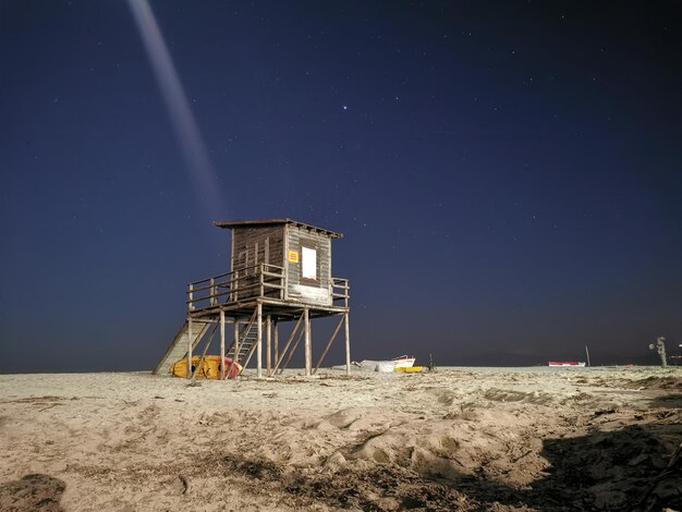 Foto lifeguard hut op het strand tegen de hemel's nachts